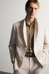 Blazer regular fit de lino color azul marino, con cuello de solapas de muesca, cierre frontal de un botón, bolsillos de solapa en la cadera y bolsillo de vivo en el pecho.