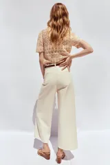 Pantalón de jean color crudo, de tiro alto, corte wide leg cropped y cinturón marrón.