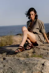 Sandalias de cuero marrón con diseño de tiras múltiples, hebillas metálicas ajustables y detalle de cuero con pelo estampado en la parte frontal. Presentan una base cuadrada y cierre de pulsera en el tobillo.