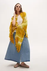 Chaleco tipo poncho tejido a crochet con diseño tie-dye en tonos amarillo y blanco, con flecos en el ruedo.