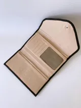 Billetera de cuero negro con diseño de solapa en forma de V y textura combinada de cuero liso y efecto croco. Cuenta con cierre mediante broche a presión.