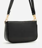 Cartera tipo shoulder baguette de tamaño pequeño, confeccionada en poliuretano con textura símil reptil. Presenta un diseño estructurado con cierre superior, correa larga ajustable y removible, y una cadena metálica decorativa en la parte frontal.