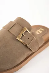 Zueco abierto de cuero gamuzado color visón, con hebilla ajustable y suela marrón con ranuras.