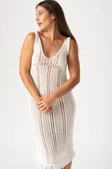 Vestido blanco de algodón con tejido calado y flecos en el ruedo.