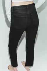 Jeans de tiro alto con diseño cropped flare, confeccionados en denim azul con acabado desgastado. Presentan cinco bolsillos, cierre frontal con cremallera y botón metálico, y bajo con terminación sin costuras.