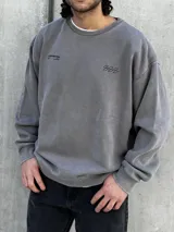 Buzo gris de corte oversize con cuello redondo y puños ajustados. Estampado en la espalda con la palabra "UNEXPECTED" y la frase "JOIN THE ROAD - POWER CONNECTION".