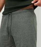Pijama corto masculino compuesto por una musculosa de algodón en color verde oscuro y una bermuda gris melange con cintura elástica.