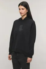 Buzo hoodie oversize negro, confeccionado en rústico de algodón y poliéster, con capucha, bolsillo tipo canguro y detalle de estampa de botas vaqueras con tachas en el centro del pecho.
