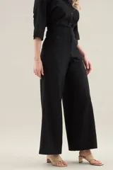 Pantalon largo de lino color tostado, tiro alto, corte ancho y recto, con costuras centrales decorativas y bolsillos laterales.