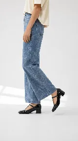 Zapatos de tacón bajo tipo Mary Jane con tira en T, confeccionados en charol color burdeos, con puntera cuadrada y cierre de hebilla lateral.