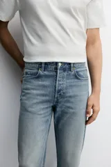 Jeans regular fit de denim de algodón en color gris con efecto lavado, tiro medio, diseño de cinco bolsillos y cierre frontal con botones.