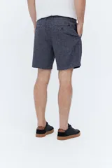 Bermuda estilo chino confeccionada en mezcla de lino y algodón, color azul melange, de corte suelto, cintura elastizada con cordón ajustable y pinzas delanteras.