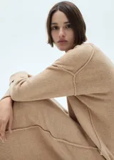 Vestido midi de punto con diseño recto, cuello redondo y manga larga con detalle de vuelta. Presenta terminaciones en canalé y un tejido de punto medio.
