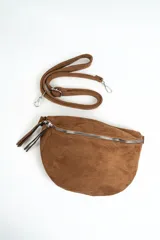 Bandolera tipo riñonera de gamuza color marrón, con cierre principal plateado y tiradores largos. Incluye correa regulable desmontable.