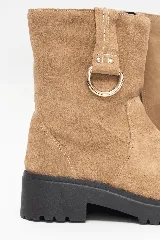 Bota corta de cuero nobuck color avena, con suela track negra, taco bajo y detalle de tira con argolla metálica en el lateral.