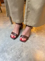 Sandalias de tacón cuadrado medio, con diseño de tiras finas y cierre de pulsera ajustable al tobillo. Confeccionadas en cuero sintético, presentan una punta cuadrada y un estilo minimalista y versátil.