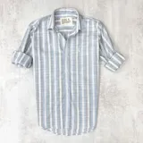 Camisa de manga larga con cuello clásico y cierre con botones. Diseño a rayas verticales en gris, celeste y blanco.