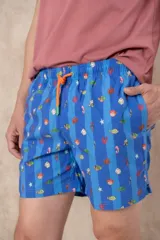 Short de baño azul con rayas verticales en dos tonos de azul. Presenta un estampado repetitivo de fauna marina (peces, caballitos de mar, cangrejos, estrellas de mar y corales) en colores vivos. Tiene cintura elástica con cordón de ajuste naranja.
