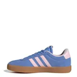 Championes Adidas VL Court 3.0 de estilo urbano, confeccionados en gamuza sintética color azul con las icónicas tres tiras laterales en color rosado. Presentan una suela de goma color caramelo y un diseño inspirado en el calzado retro de canchas.