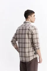 Camisa de manga larga confeccionada en viyela de algodón con diseño de cuadros en tonos azul y verde. Presenta cierre frontal con botones, cuello clásico y bolsillo en el pecho.