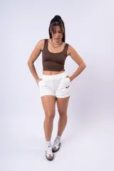 Short deportivo blanco de calce holgado, con cintura elástica y logo bordado en negro.