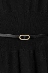 Vestido midi de punto en color negro, con cuello barco y mangas largas con sisa ancha. Presenta una cintura entallada con un cinturón fino incorporado con hebilla metálica dorada.