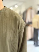 Buzo oversize marrón de manga larga, confeccionado en tela texturada con líneas verticales, cuello redondo y calce holgado.