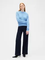 Sweater de punto con diseño de trenzas en toda la prenda, cuello redondo, mangas largas y puños acanalados.