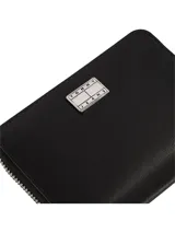 Billetera negra con cierre de cremallera y logo Tommy Jeans en el frente.