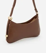 Cartera baguette marrón con textura croco, confeccionada en material sintético. Tiene cierre de cremallera y correa de hombro con esferas doradas.