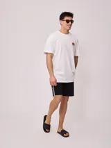 Short de baño color verde menta con cordón de ajuste en la cintura y una franja lateral con diseño de rayas en negro y blanco.