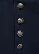 Pantalon de tiro medio con diseño recto y corte crop. Presenta detalles de botones decorativos efecto joya en la parte frontal y cierre oculto con cremallera y gancho.