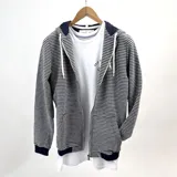 Campera con capucha y cierre frontal, a rayas horizontales azul marino y blanco, con puños y cintura en azul marino.