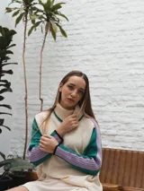 Buzo de punto con cuello alto, diseño de bloques de color en crema, verde y lila, con mangas largas y corte holgado.