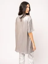 Remera blanca oversized de tela elastizada con tajos laterales y escote redondo.