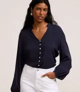 Camisa azul marino de viscosa con cuello mao, cierre frontal con botones y mangas largas con puños elásticos.