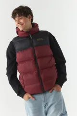 Chaleco puffer color borgoña y negro, con capucha y cuello alto.