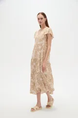 Vestido midi de viscosa con estampado floral en tonos celeste y blanco, cuello en V, mangas cortas y diseño holgado con volados escalonados en la falda.