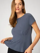 Remera de manga corta color azul grisáceo, confeccionada en tejido de modal, con cuello redondo y detalle de alforzas verticales en el frente que aportan estructura y una caída relajada.
