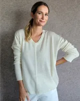 Sweater color crema de lana lambswool, con escote en V y corte holgado.