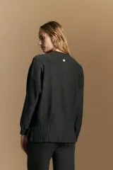 Polera de tejido de punto color marrón, con cuello alto y diseño de líneas verticales en el frente que aportan estructura. Presenta un calce relajado y mangas largas con puños ajustados.
