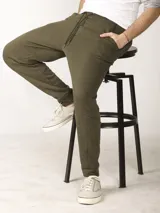 Pantalón jogging slim fit color verde militar, con cintura elástica ajustable con cordón, bolsillos frontales y un bolsillo trasero con cierre invisible. Presenta detalles de cortes diagonales en las piernas y bajo con puño doble tela.