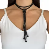 Collar largo de diseño versátil confeccionado en strass negro, con un nudo decorativo y terminaciones en forma de borla.