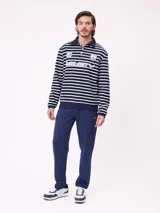 Polo de manga larga con diseño a rayas horizontales en azul marino y blanco. Presenta cuello tipo polo con cierre de botones, estampado frontal con el logo de la marca y el número 85, y puños elásticos.
