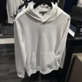 Hoodie Michael Kors de color blanco con estampado monograma en gris claro, cuenta con capucha y bolsillo frontal tipo canguro.