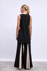 Blusa sin mangas color negro, de corte recto y largo irregular.