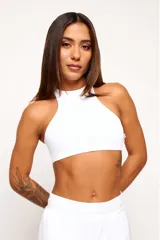 Top deportivo de cuello alto, confeccionado en tejido de poliamida y elastano. Presenta un diseño minimalista, ajuste al cuerpo y forro interno para mayor soporte.