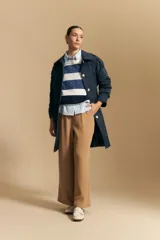 Trench azul marino de corte clásico con cuello amplio, botones frontales grandes en color beige, y detalles en los hombros.