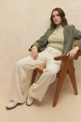 Top negro sin mangas con cuello alto y fruncido en los laterales. Es elastizado y cuenta con un botón a tono en la espalda.