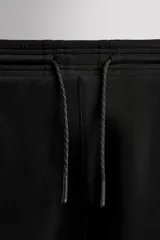 Pantalón jogger de entrenamiento, corte regular fit, color verde oliva oscuro. Confeccionado en tejido técnico compacto de algodón con elasticidad y efecto neopreno. Presenta cintura elástica ajustable con cordón blanco, bolsillos frontales y un bolsillo lateral con cierre de cremallera. El bajo termina en puño.